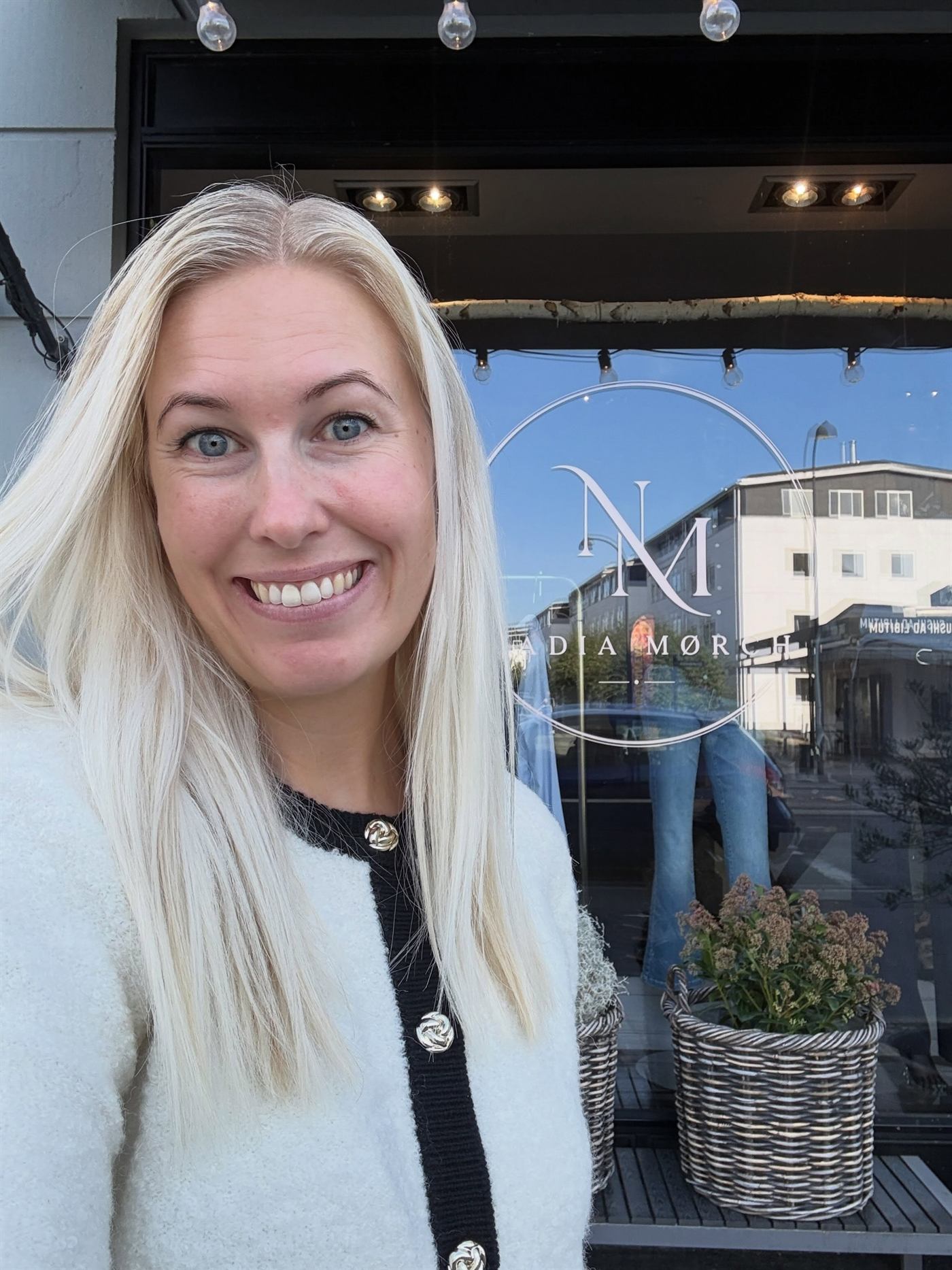 Nadia Mørch foran butiksvinduet med logoet